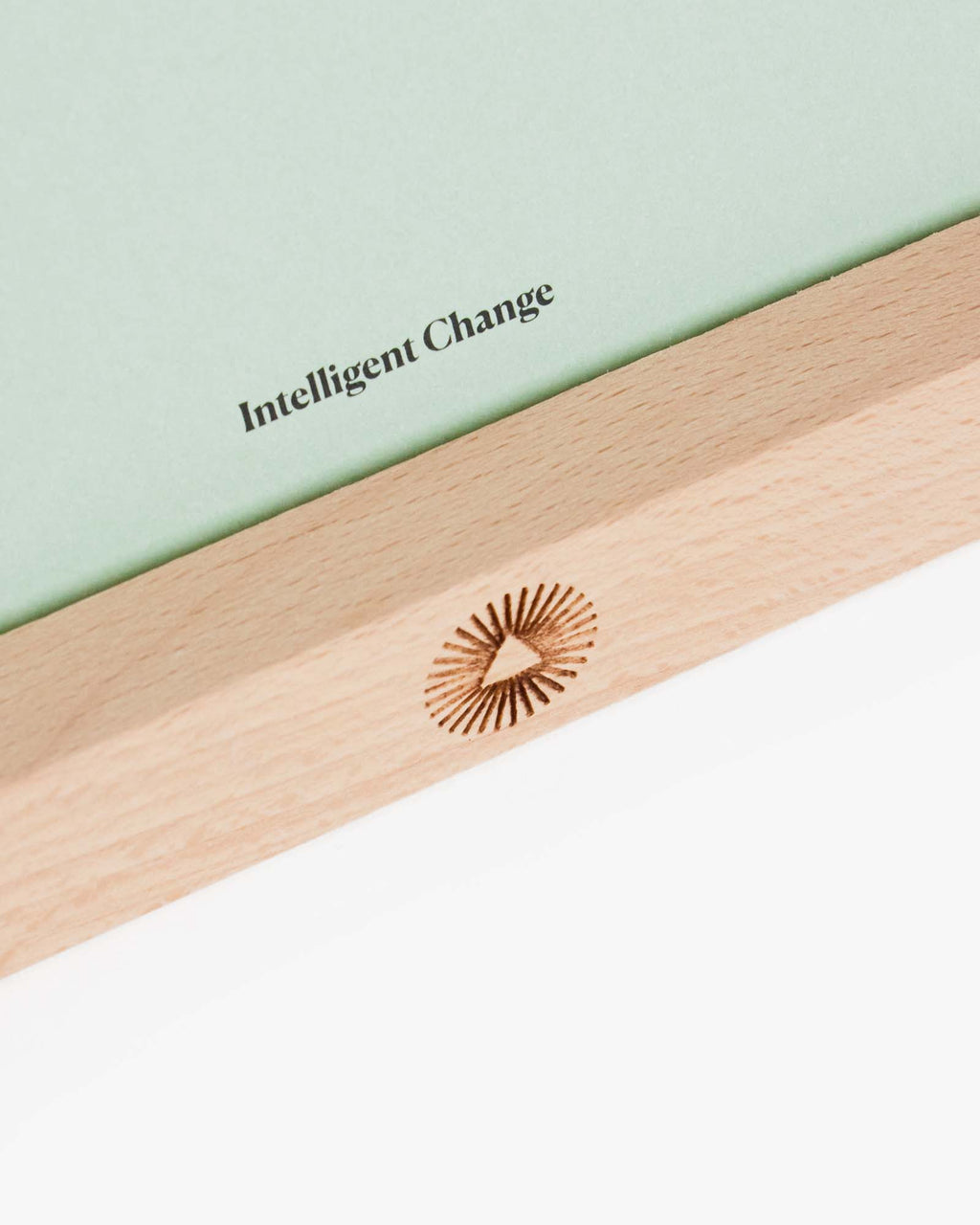 Close view of the Intelligent Change logo on the beechwood card stand.
