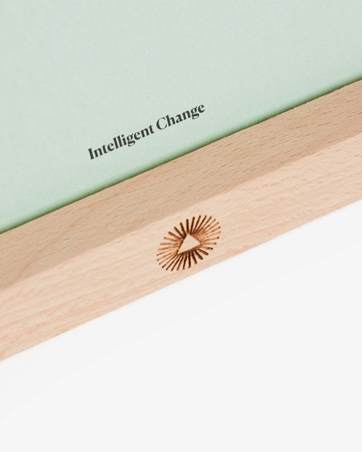 Close view of the Intelligent Change logo on the beechwood card stand.