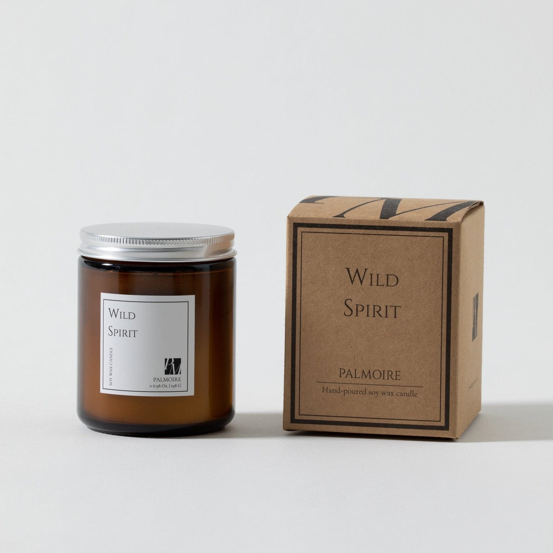 Amber glass soy wax candle with silver lid and Wild Spirit label next to brown Wild Spirit Palmore box.