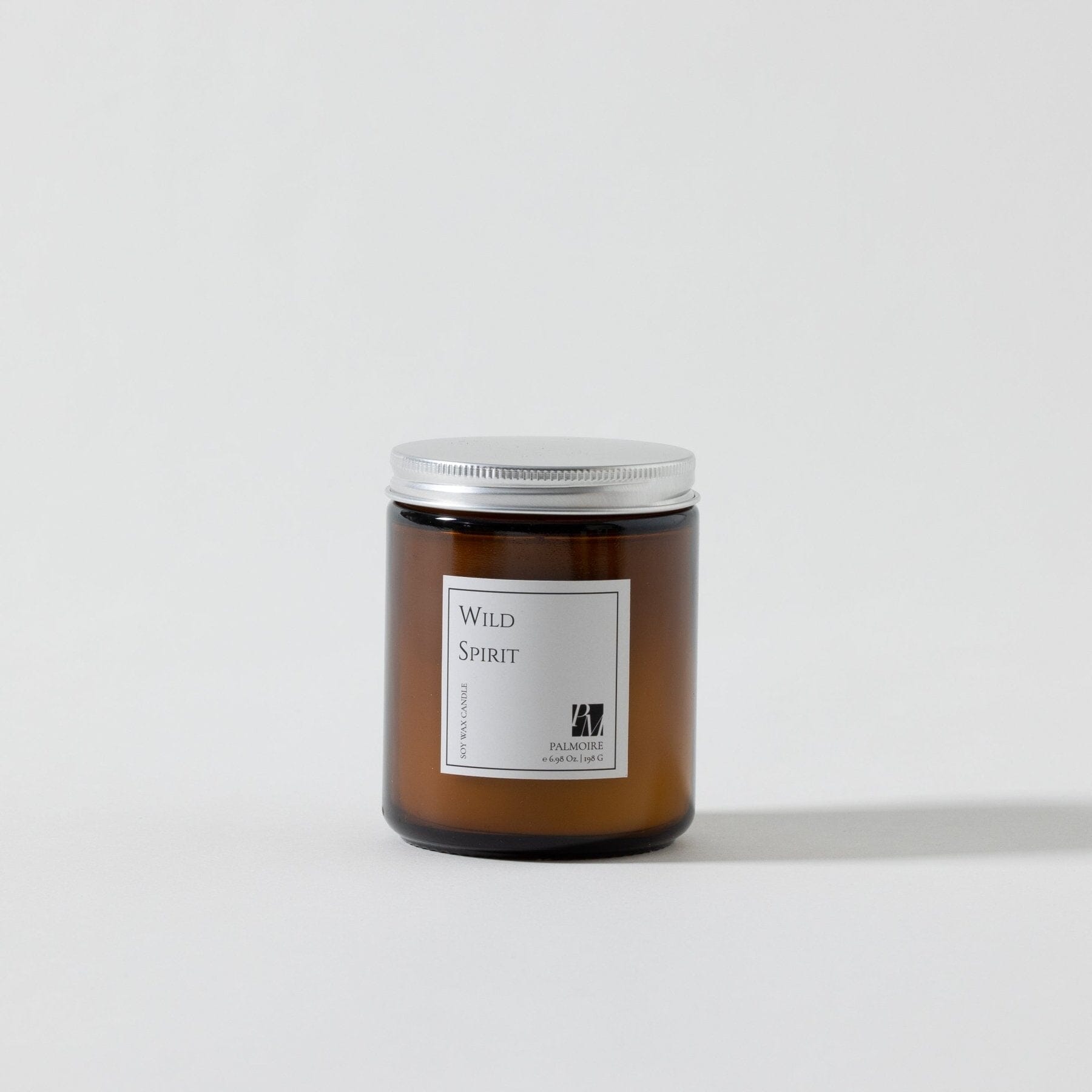 Amber glass soy wax candle with silver metal lid and minimalist Wild Spirit label.