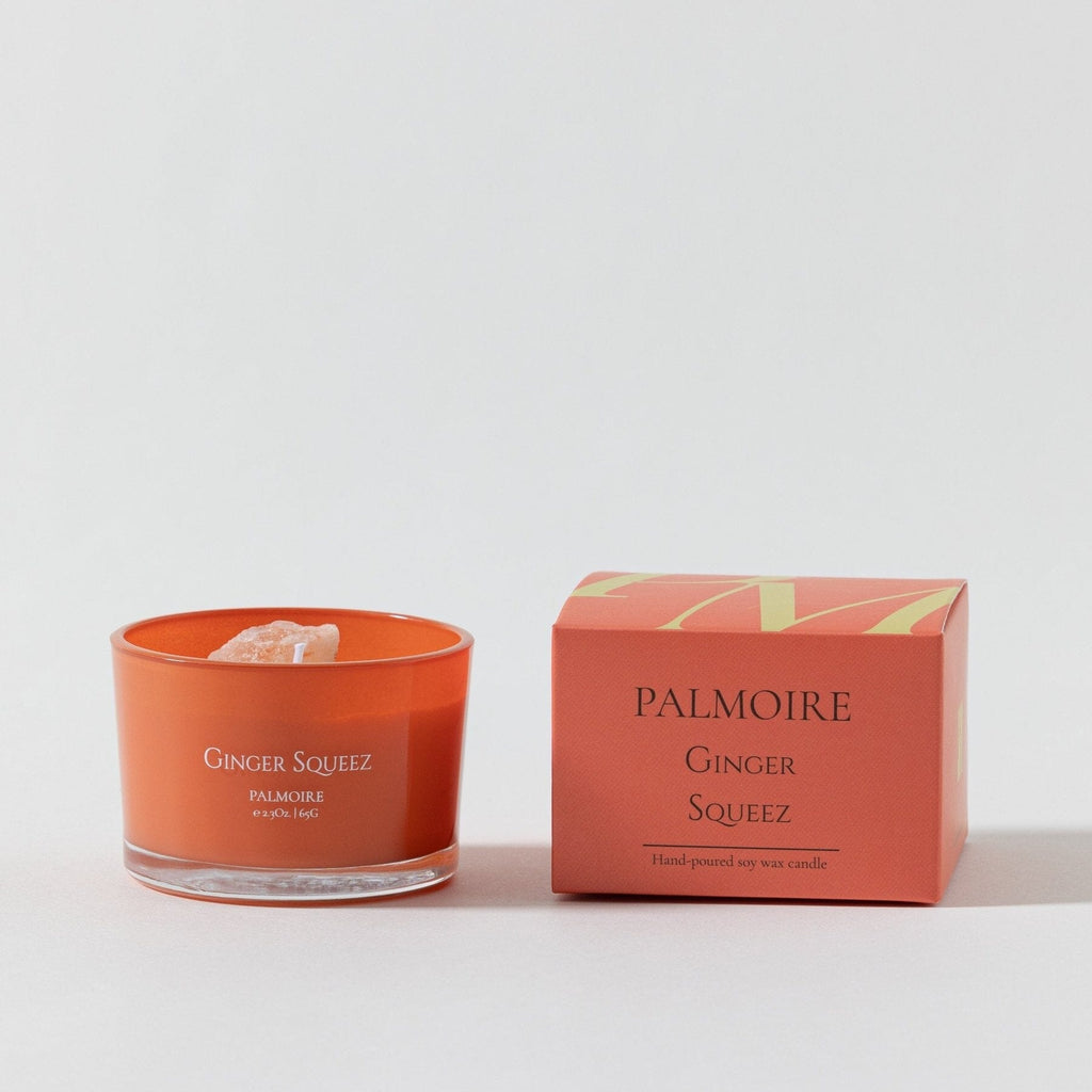Orange soy wax candle in clear glass with matching orange box labeled Palmoire Ginger Squeez.