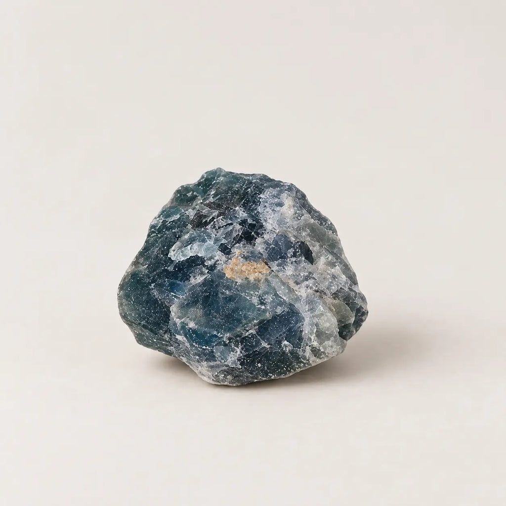LumaStone natural blue fluorite rough, representative single raw stone on warm ivory background