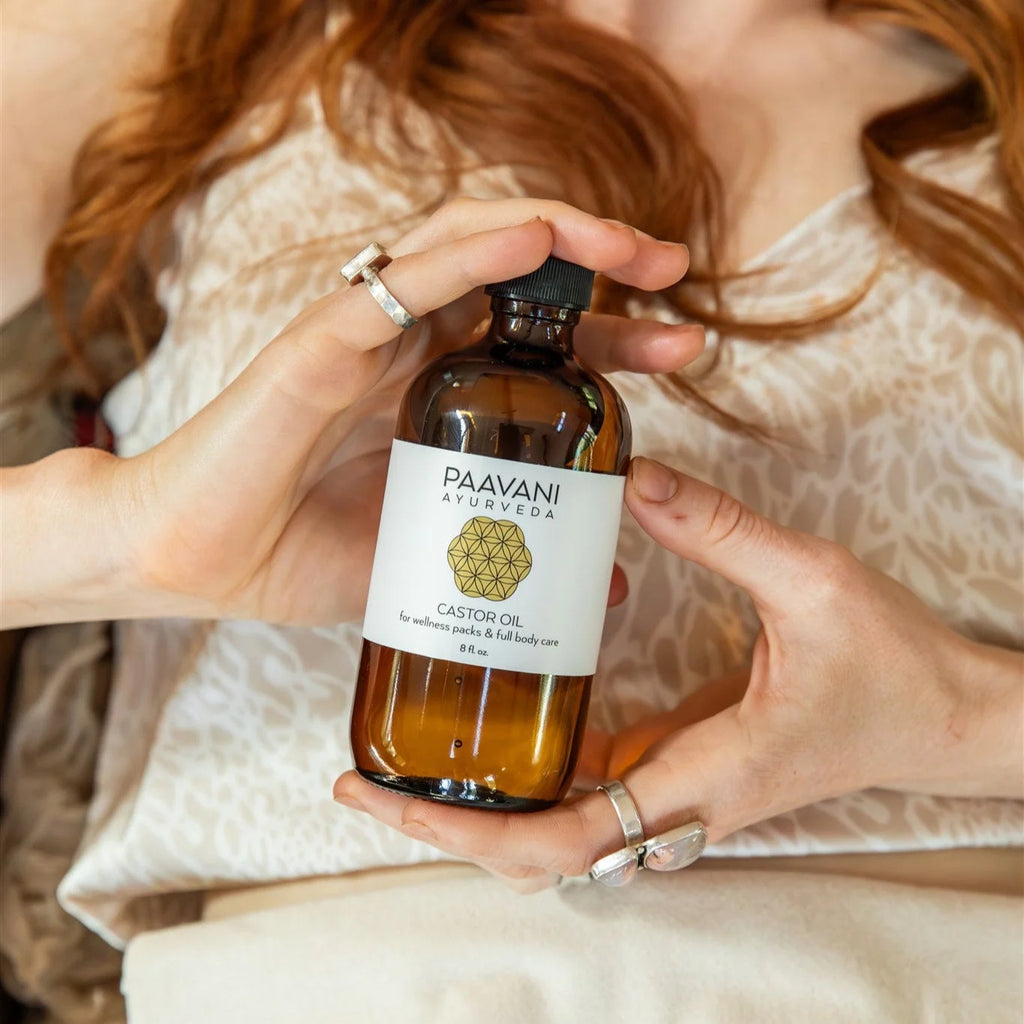 Paavani Ayurveda castor oil bottle held in hands