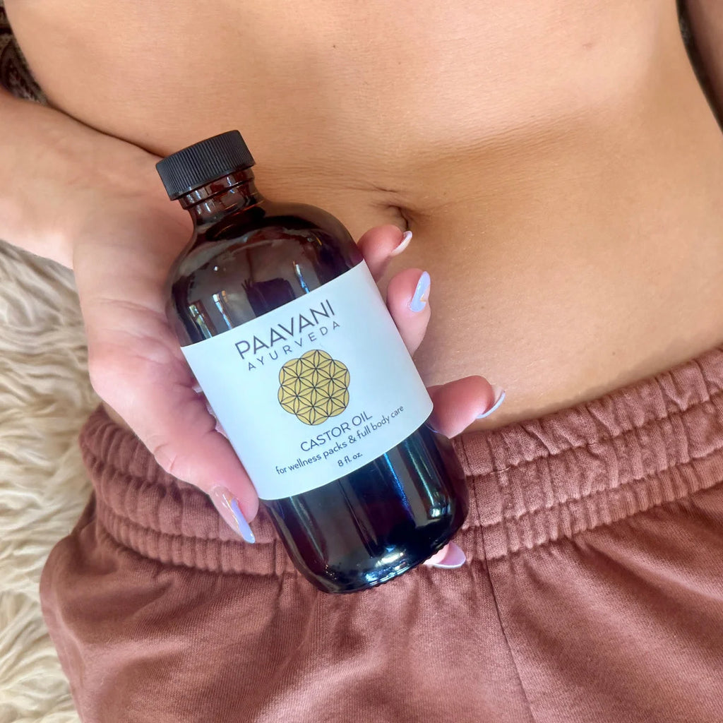 Paavani Ayurveda castor oil bottle held near the body