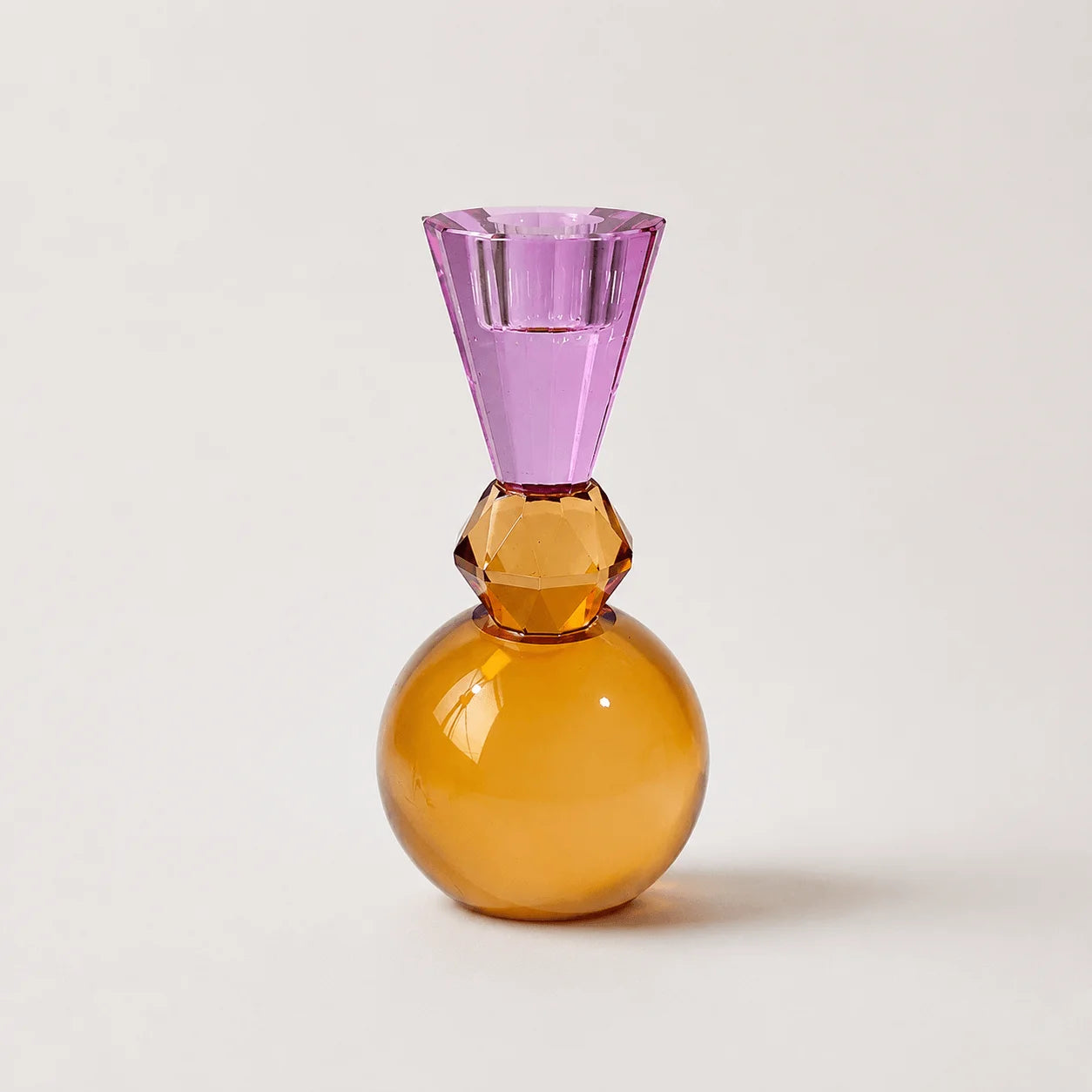 StillAura crystal multicolored candle holder; a European-style block cup holding a lit candle.
