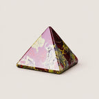 Polished dragon blood jasper pyramid crystal ornament on a warm ivory background