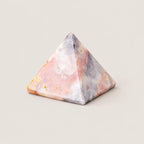 Polished agate pyramid crystal ornament on a warm ivory background