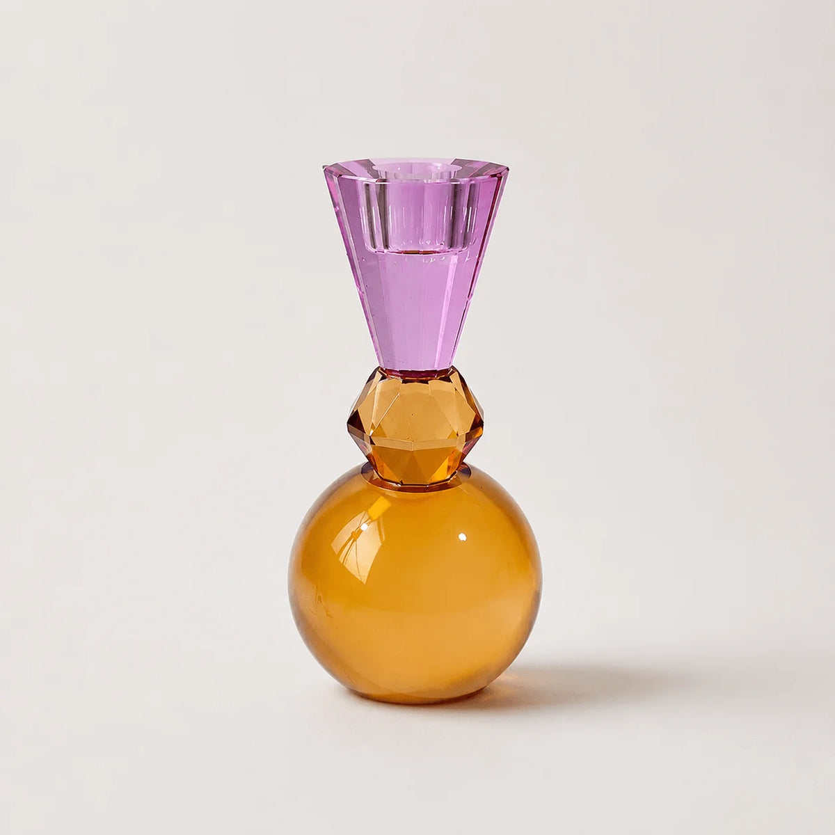 StillAura crystal multicolored candle holder; a European-style block cup holding a lit candle.