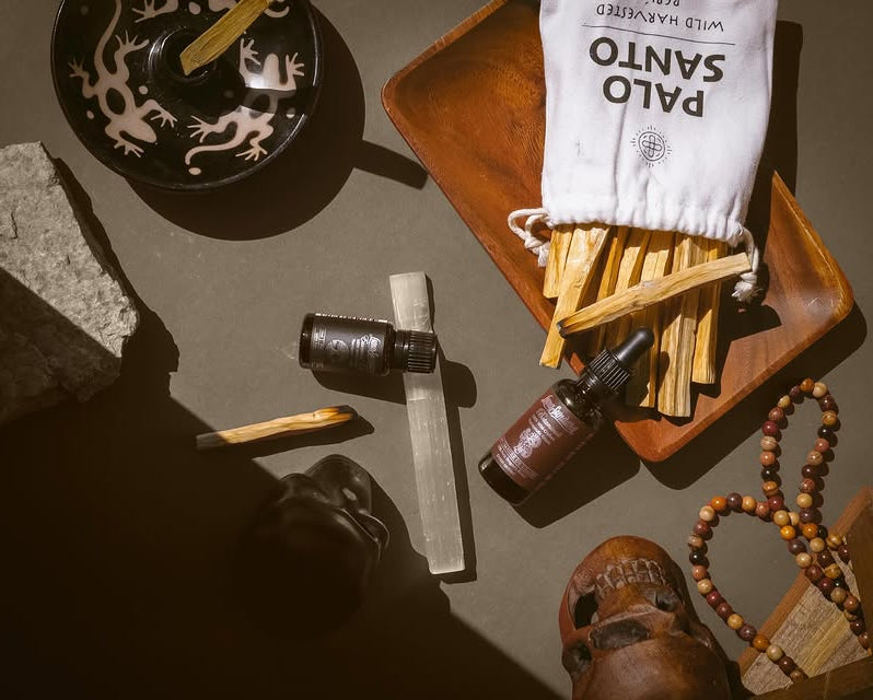 A spiritual cleansing kit featuring Palo Santo sticks, essential oil droppers, and a selenite crystal for meditation and energy clearing.